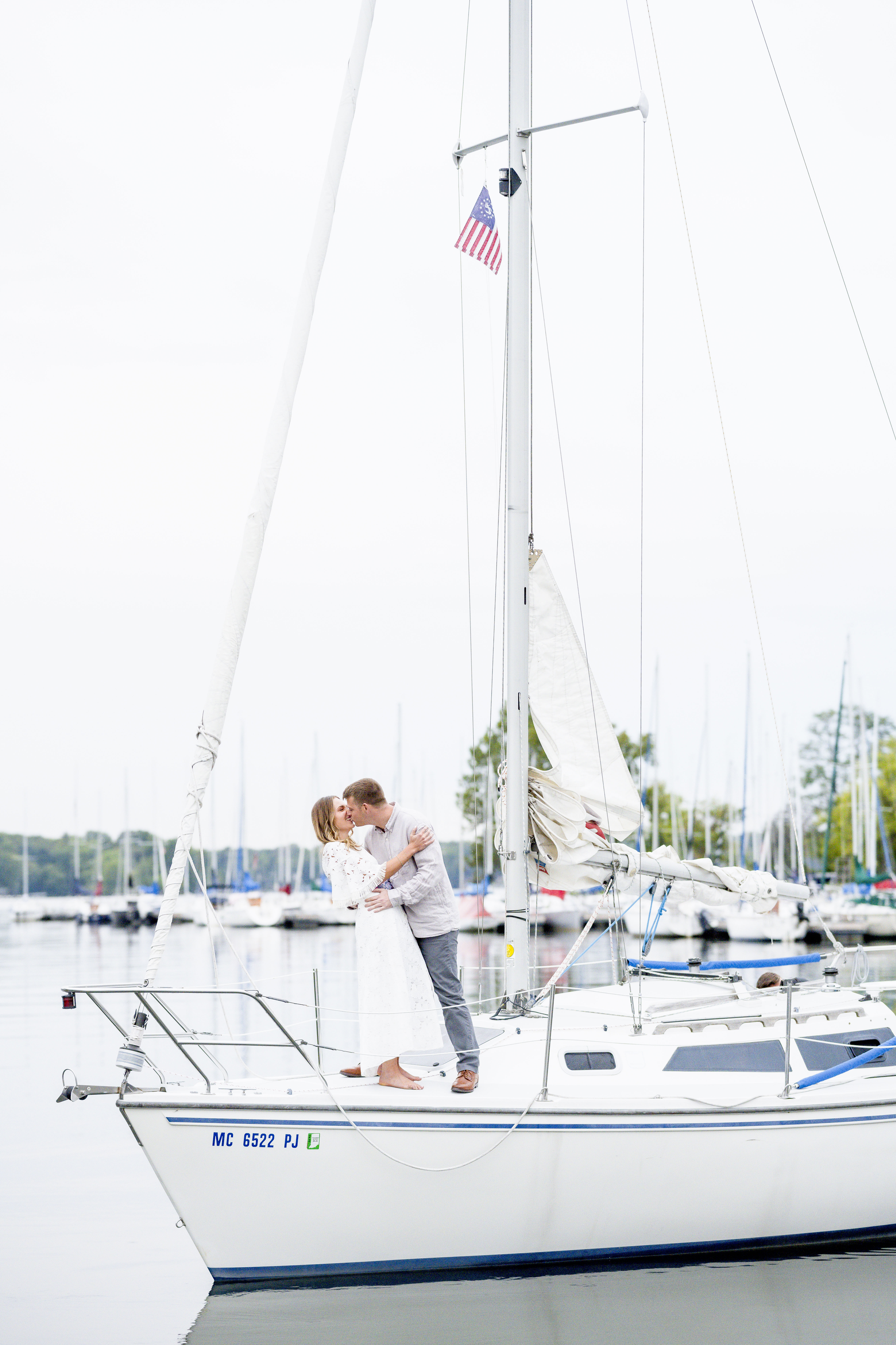 Couple kissing while on sailboat during engagement photos